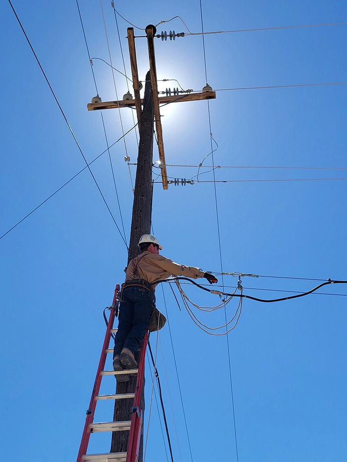 man on ladder fixing power line